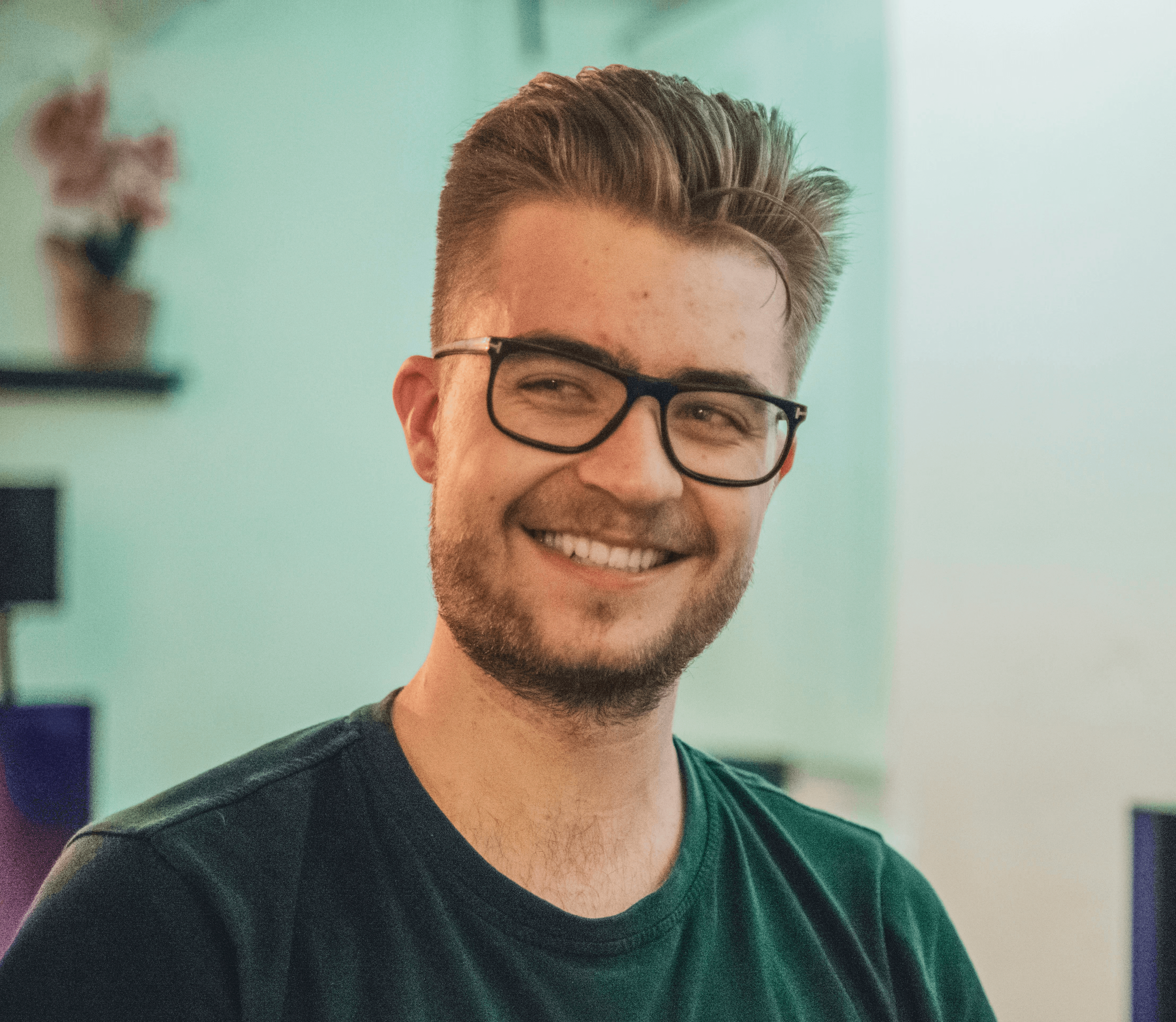 man wearing green crew-neck top and eyeglasses with black frames looking at side