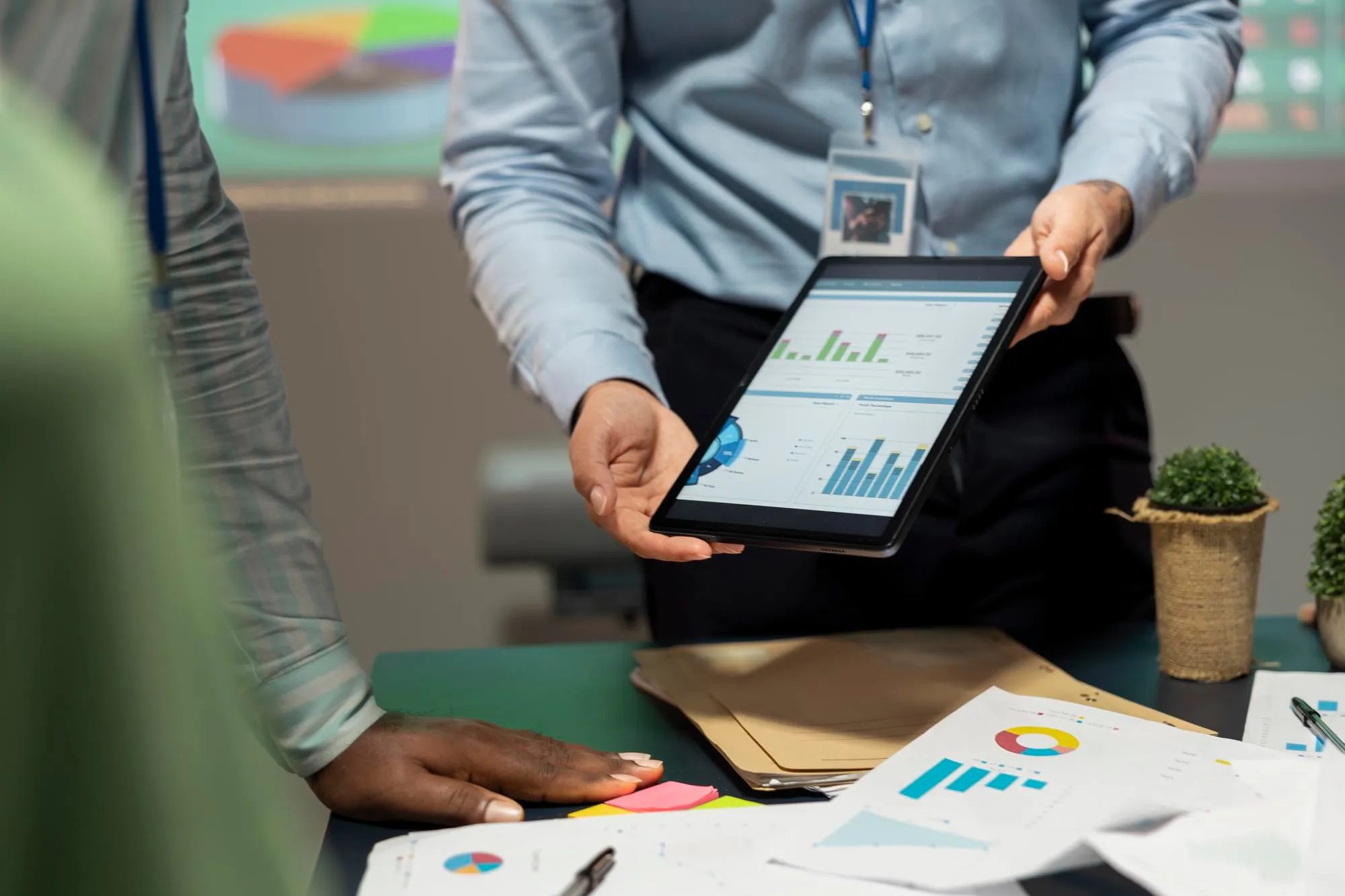 Colleague presenting an analytics dashboard on a tablet during a meeting