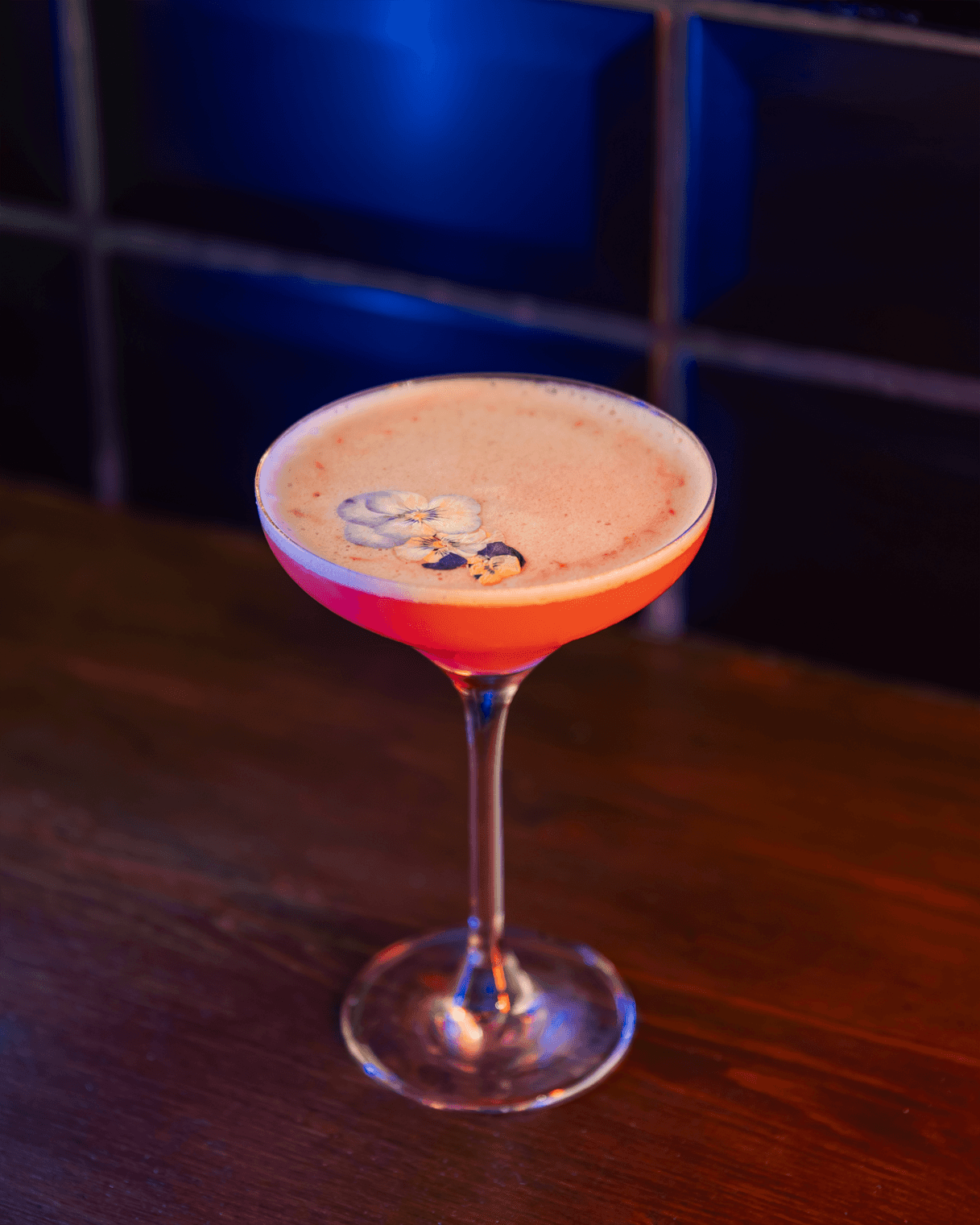 A Porn Star Martini served at Vault Shenfield, featuring a vibrant passion fruit garnish and a side of prosecco, presented in an elegant cocktail glass.