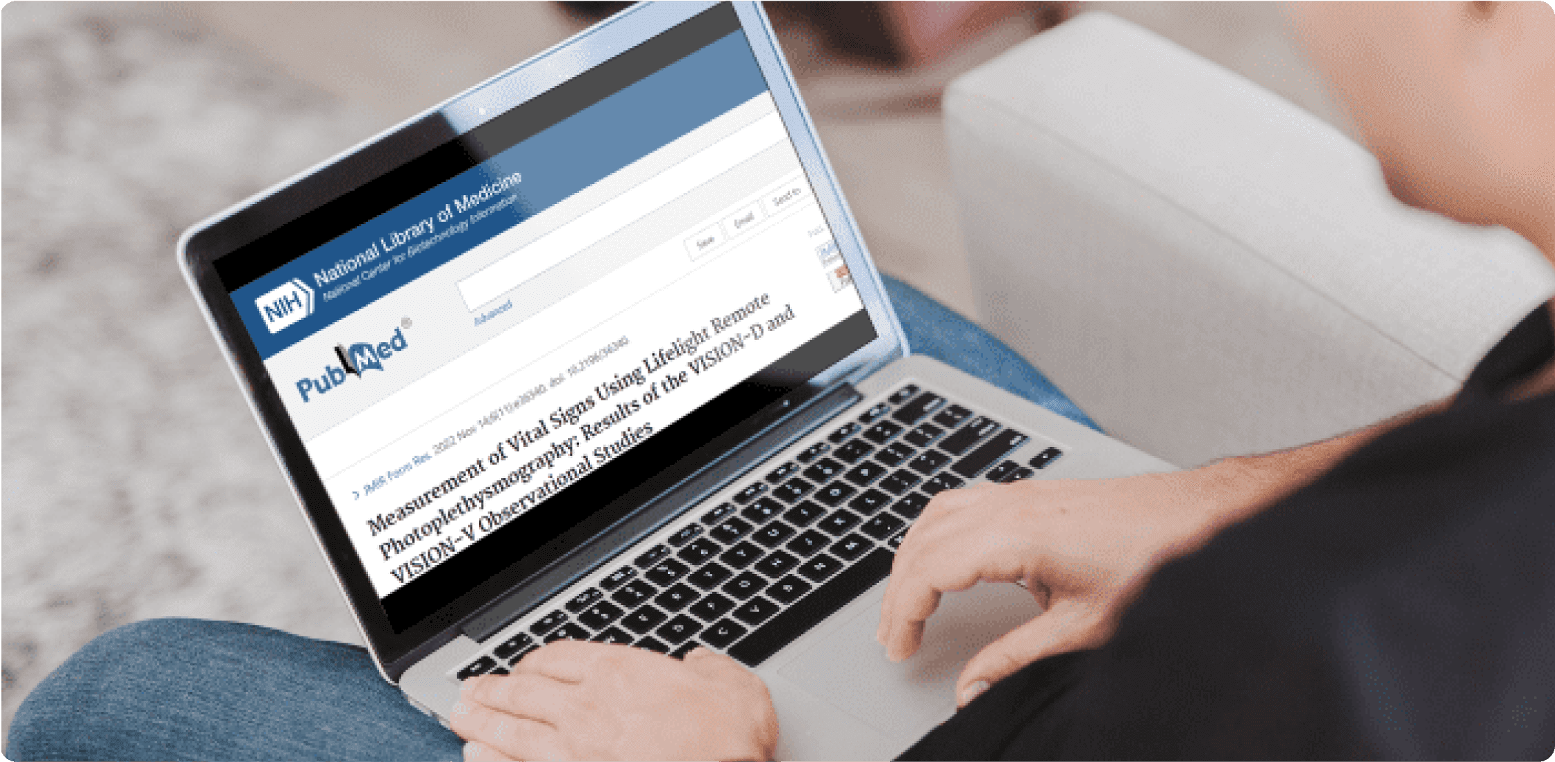 Person using a laptop, that is showing this paper by PubMed on its screen