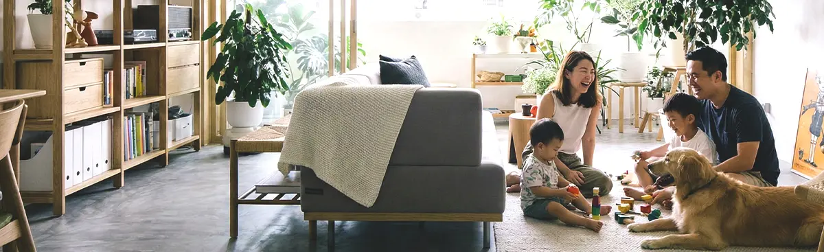asian family relaxed and indoors with pet dog