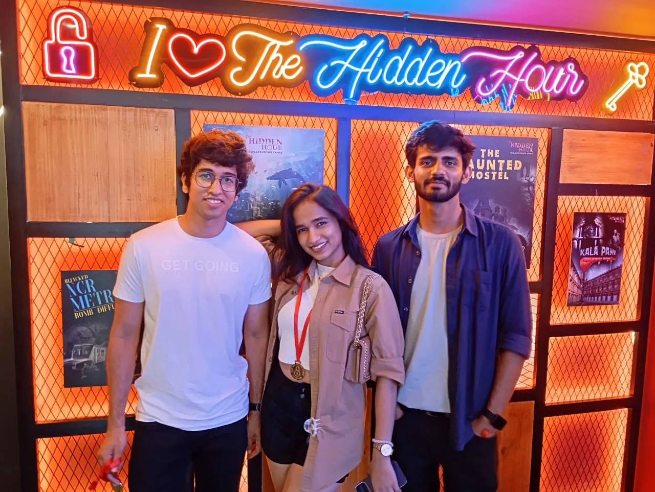 Birthday group holding props and giving a thumbs-up at Hidden Hour escape room`