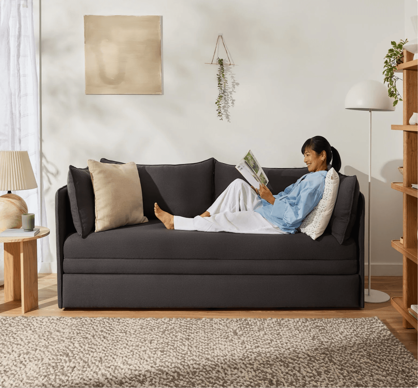 A woman sitting on a couch reading a book