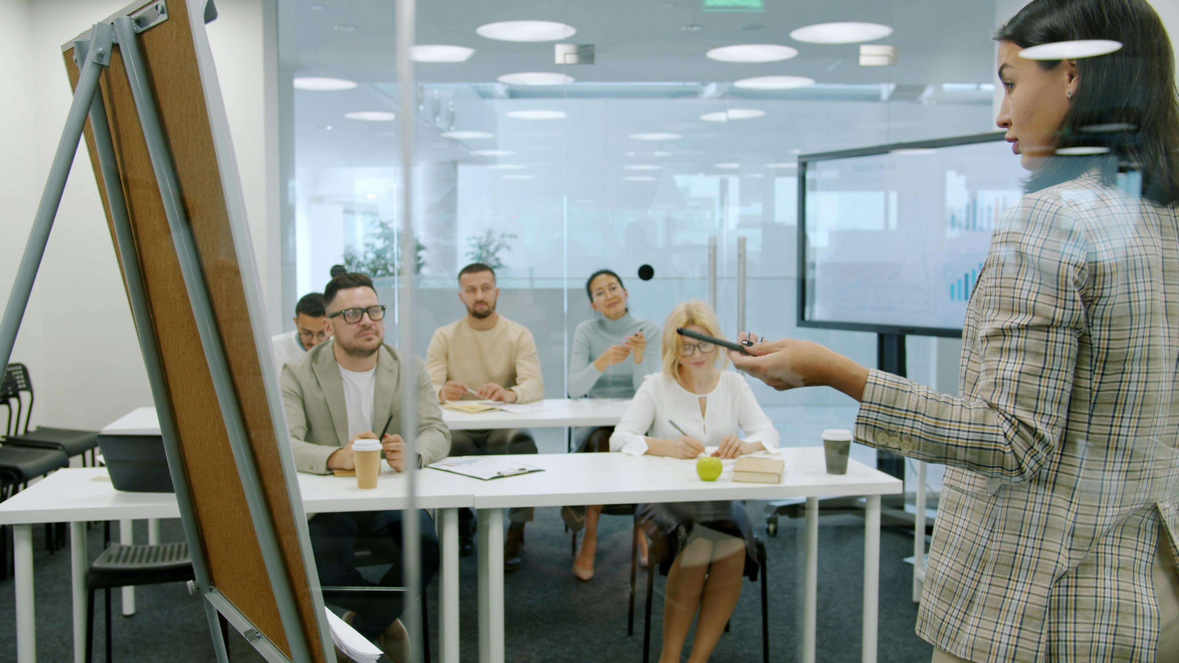 Woman presenting to a group in a modern office.
