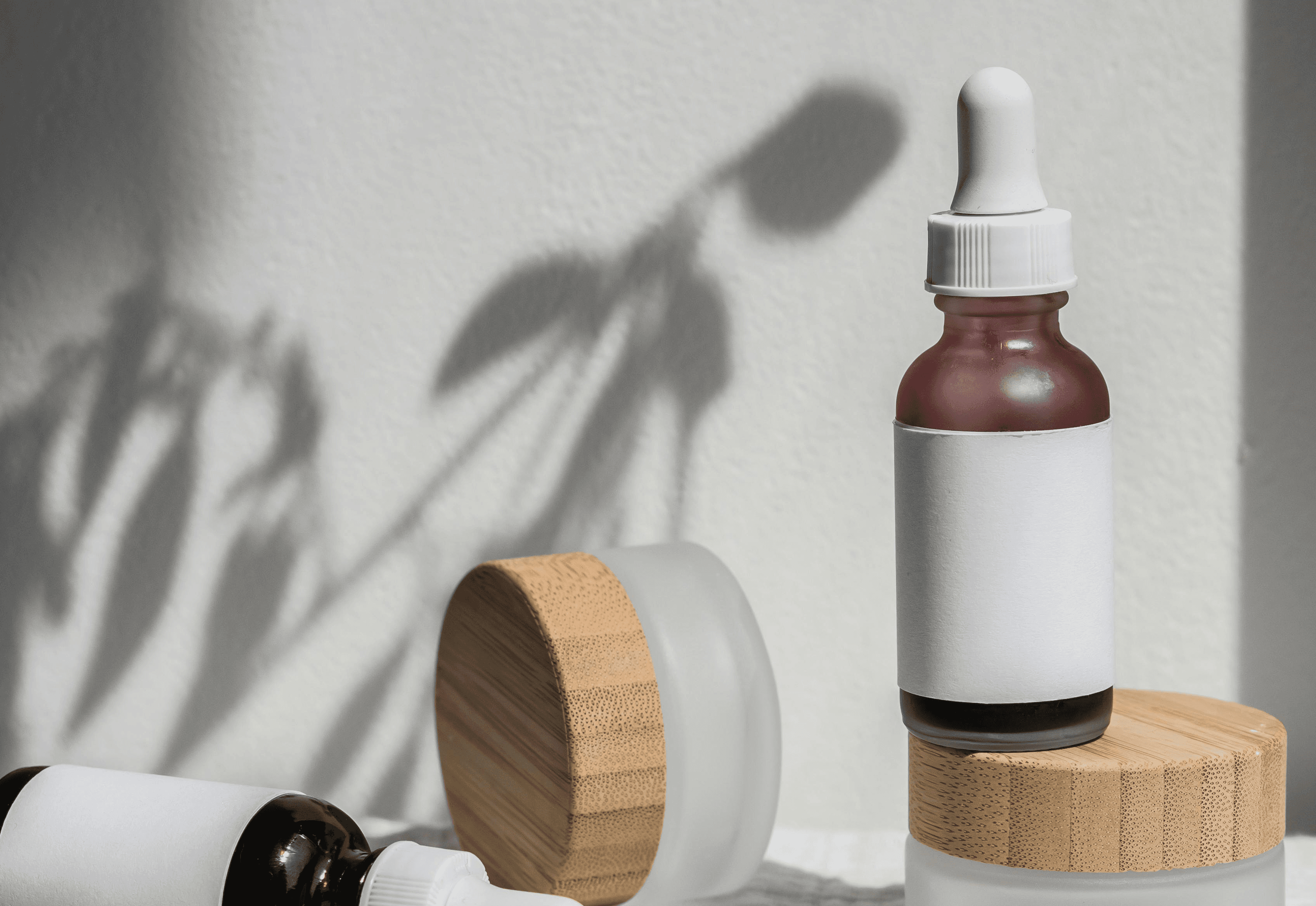 Spa products: skincare serum bottles, cream jars, and soap bar on white cloth. Natural beauty products, self-care concept.