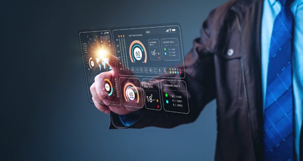 A person walks in front of large stone arches with dark doors, flanked by tall columns, in a historic building.