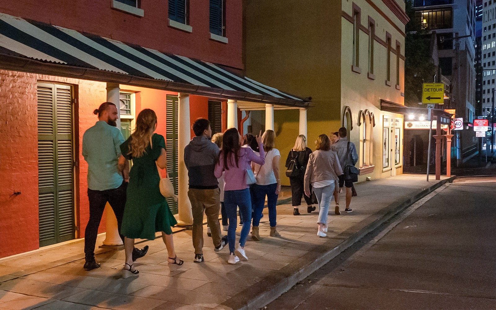 Nhóm du khách đi bộ dọc theo các tòa nhà lịch sử của The Rocks