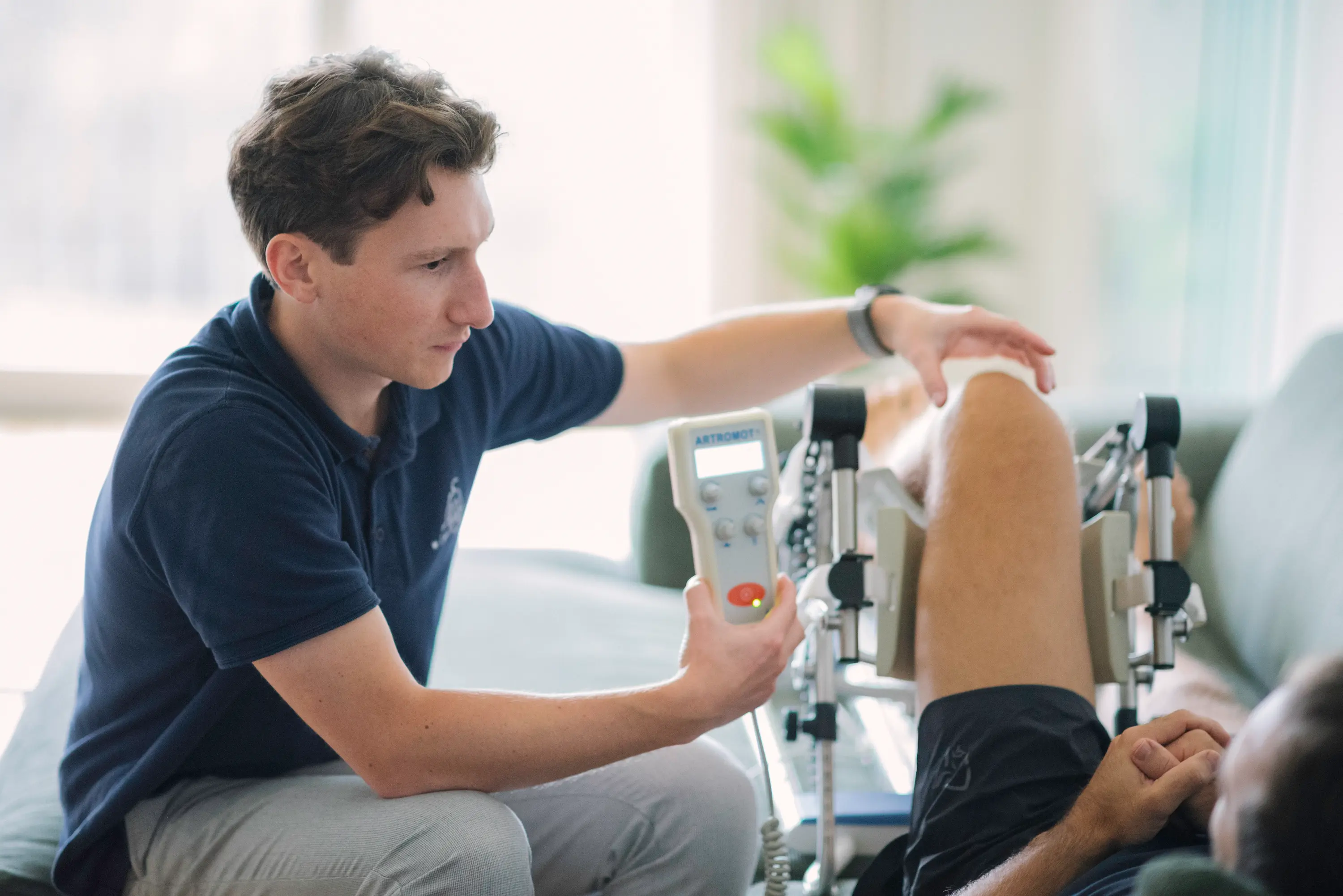 Arzt untersucht das gebeugte Knie eines Patienten
