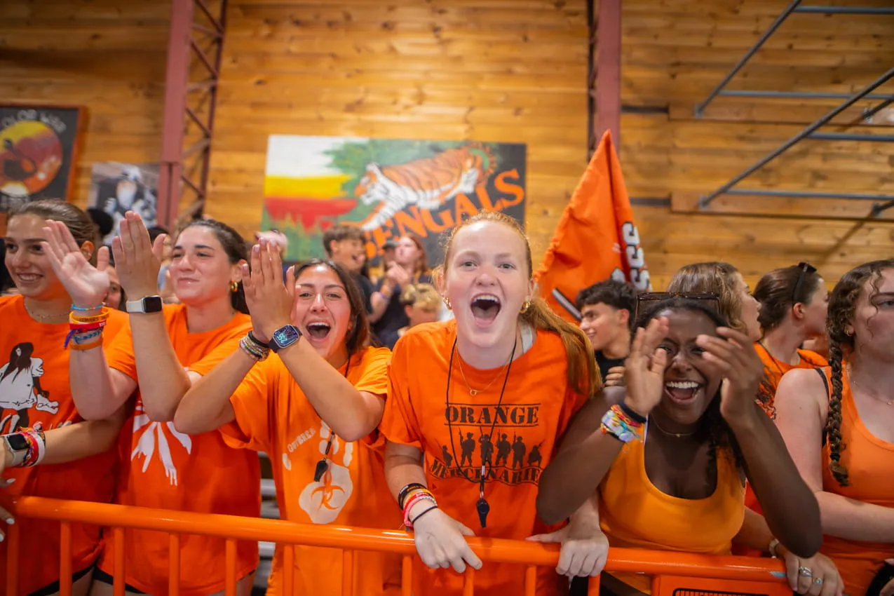 Campers in orange Lenox gear cheering together at Camp Lenox
