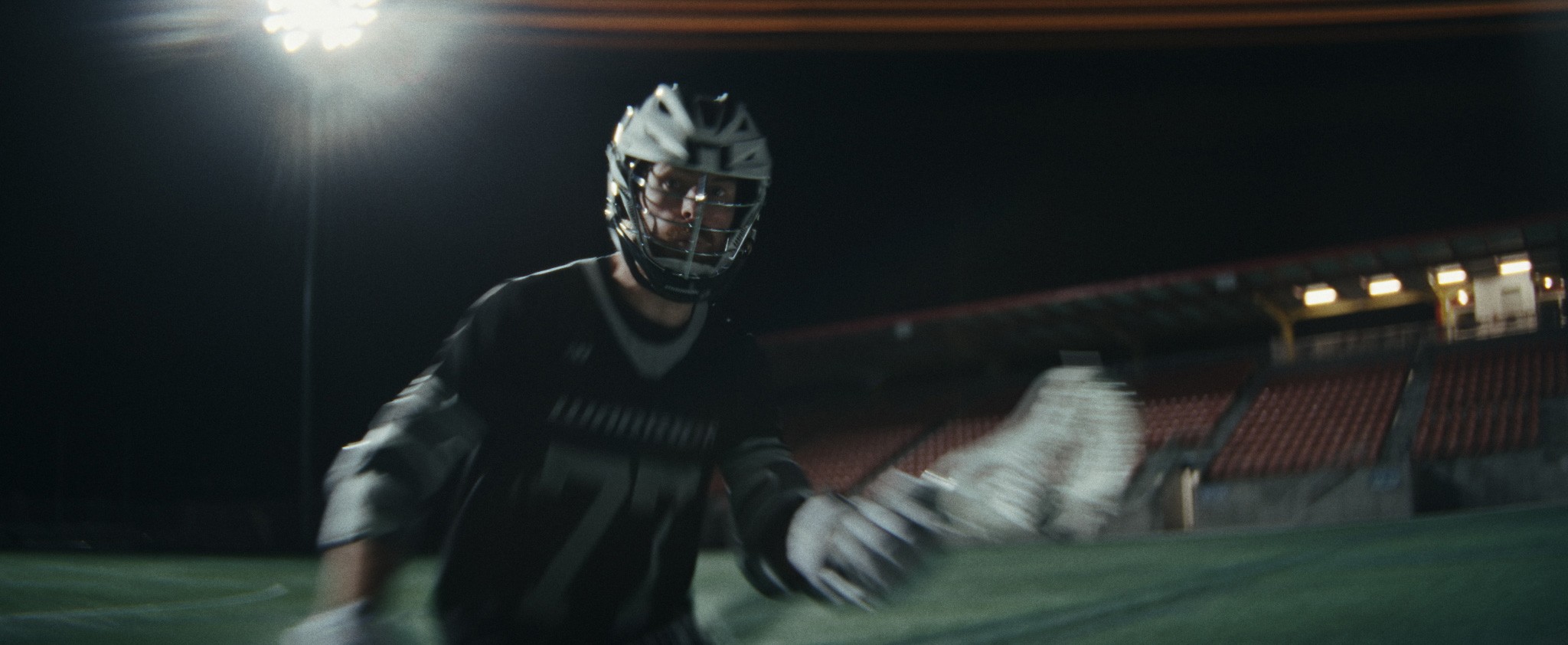 Stadium lacrosse still for Warrior Sports, cold sodium lighting and motion blur on the stick check