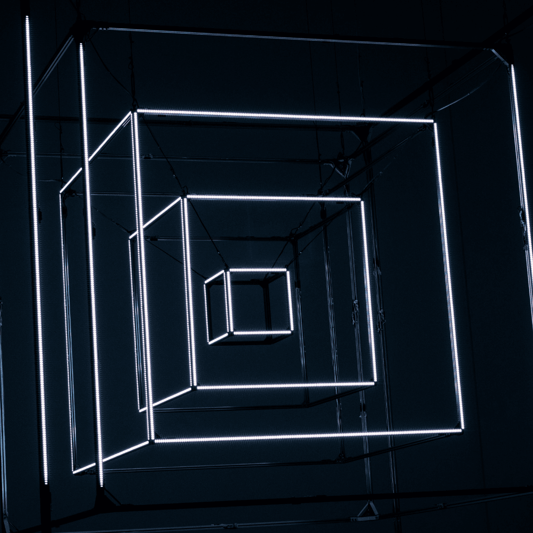 Una persona con una camiseta negra y pantalones de color claro está de pie en la cima rocosa de una montaña al atardecer, sosteniendo una cámara frente a su cara para tomar una foto. Un mar de nubes se extiende detrás de ellos, iluminado por la luz dorada del sol poniente.