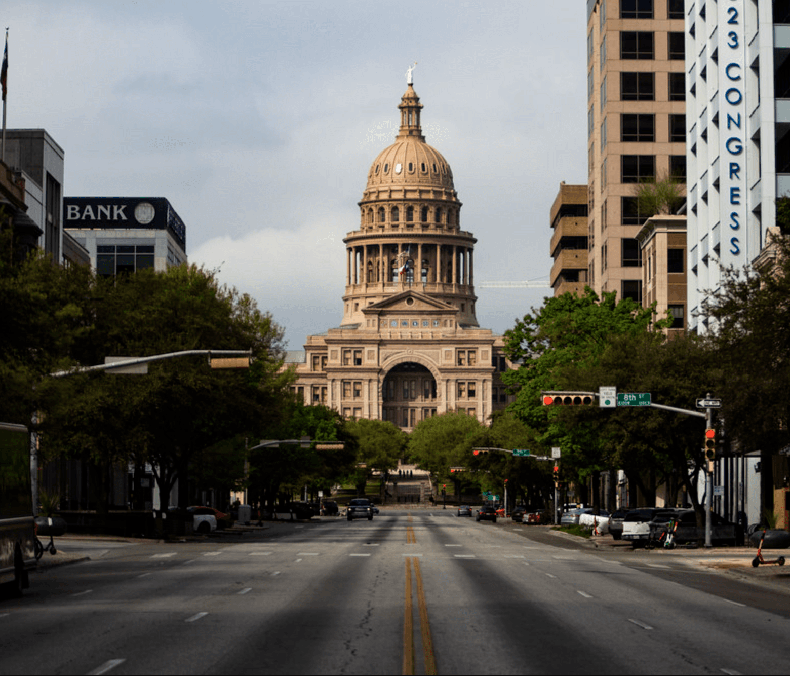 A tranquil canal in Amsterdam reflects historic buildings and the autumn-colored trees under a pastel sky with birds flying above; capturing the serene beauty and cultural architecture of the city.
