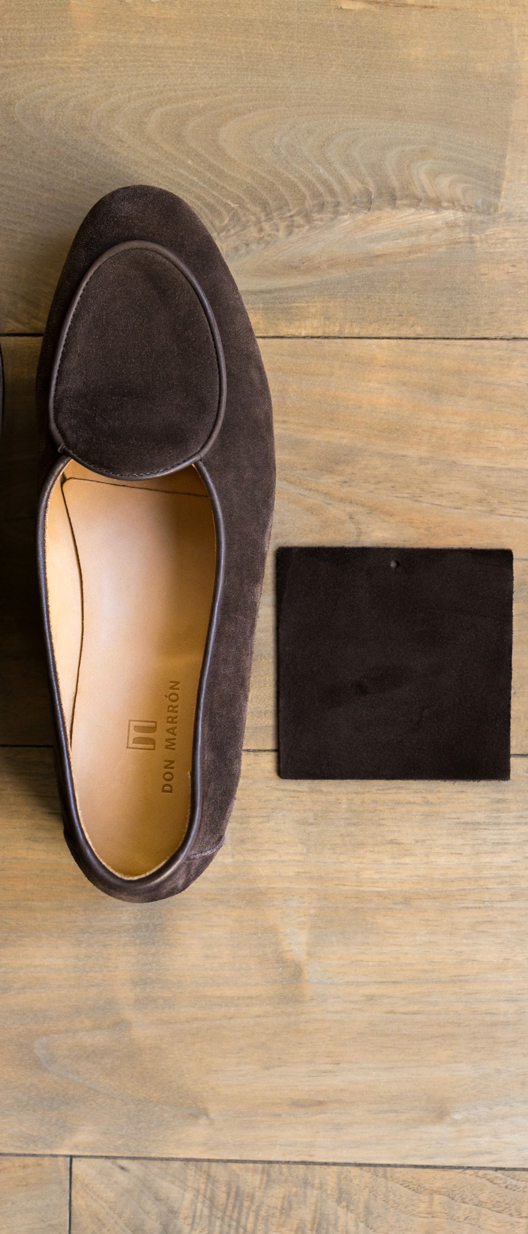 Elegant scene featuring a tailored pinstripe jacket, cologne bottle, and tailoring tools on a wooden table, symbolizing personalized wardrobe service and refined craftsmanship.