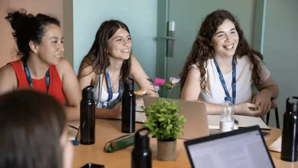 High school student working on original research paper with PhD mentor in a university setting