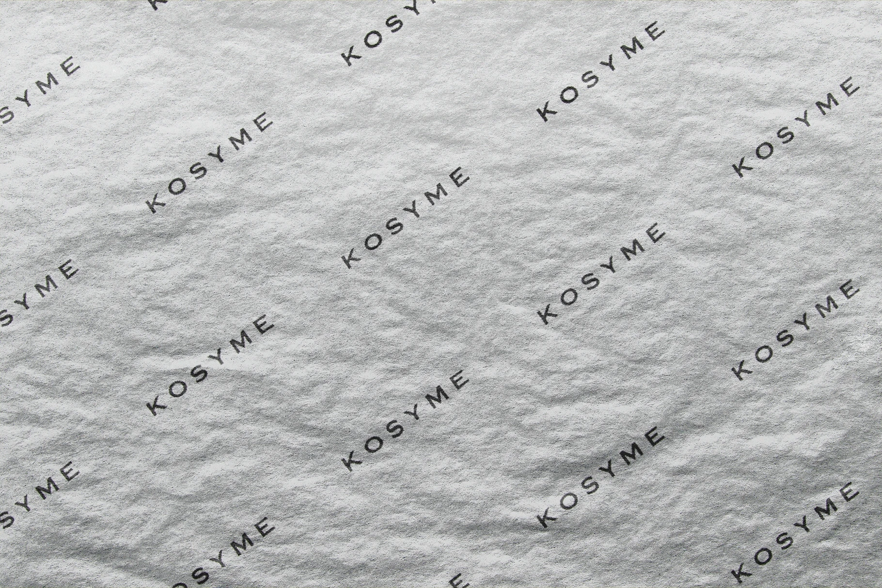A greyscale version of the wrinkled paper mockup with an embossed logo pattern.