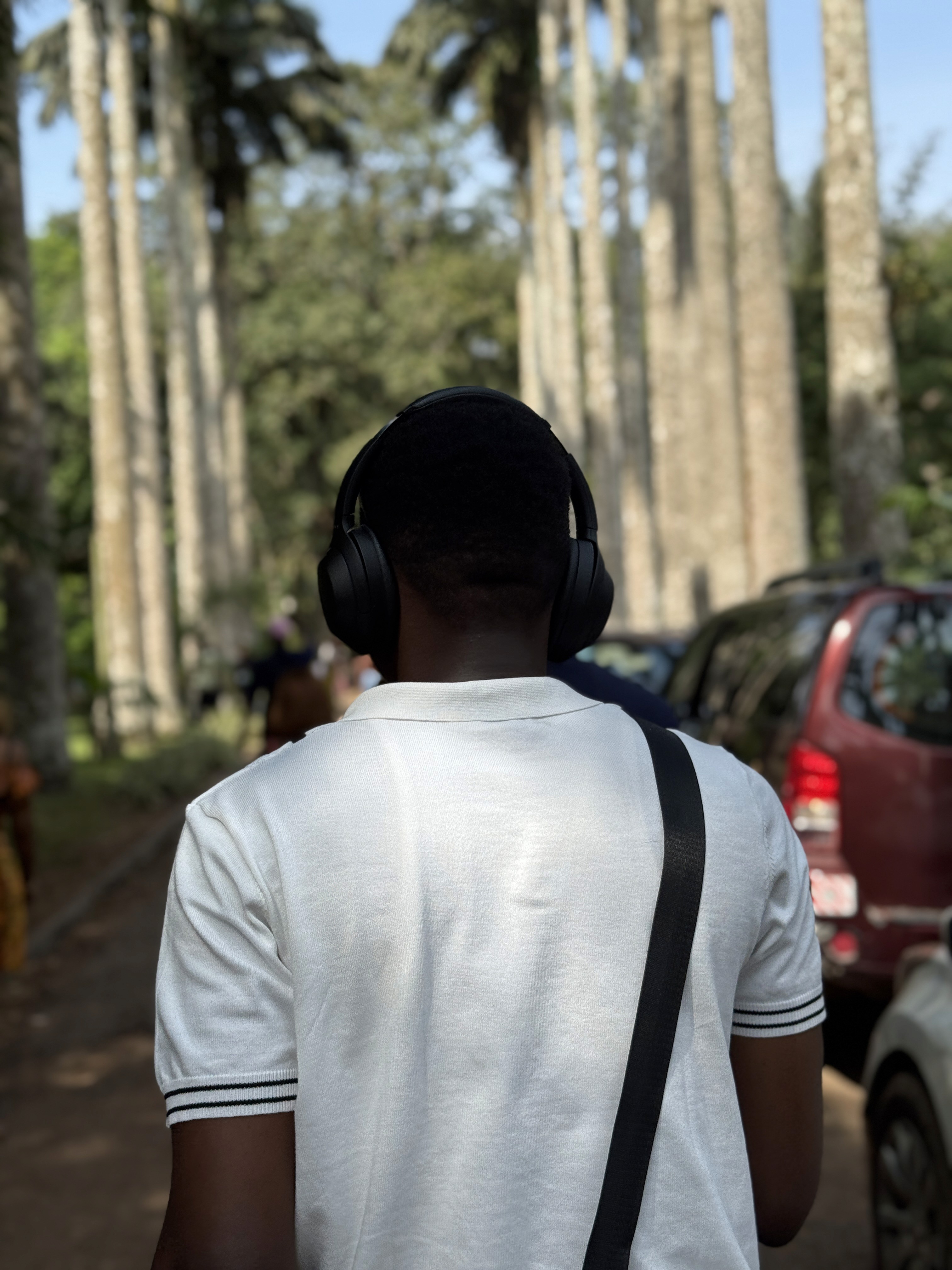A close-up of a hand wearing multiple decorative rings against a blue background.