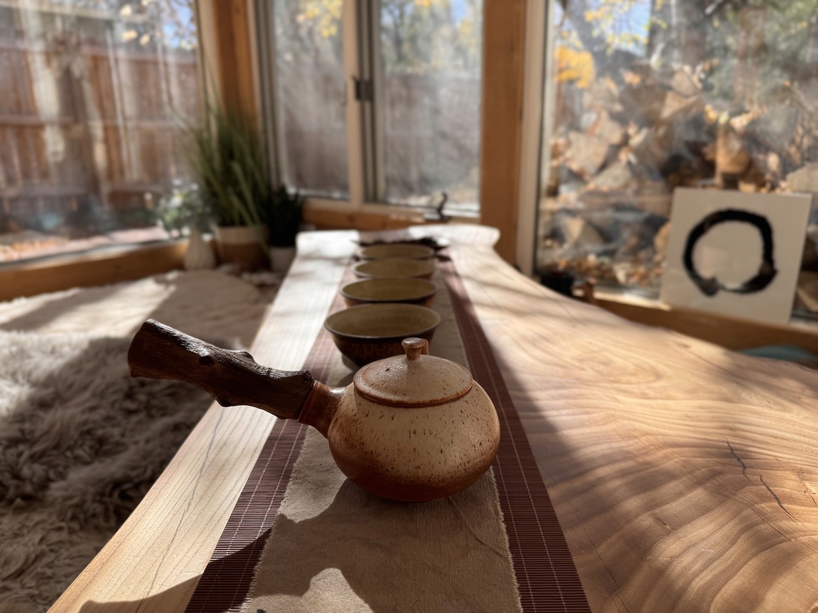 Tea ceremony setup with ceramic teapot and cups on wooden table