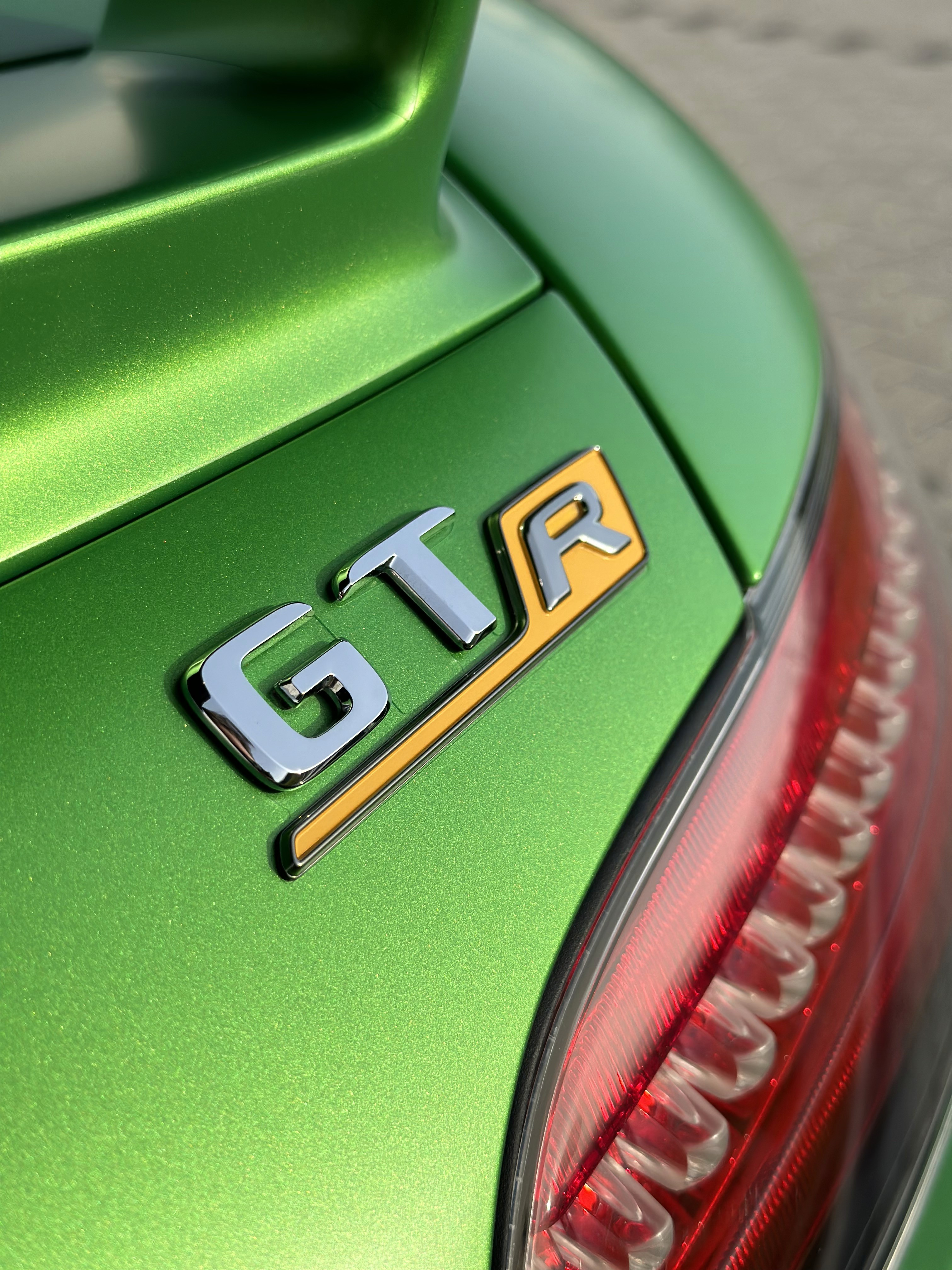 Grünes Auto mit GTR-Emblem und Spoiler, Nahaufnahme
Grüner Rennwagen mit gelben Akzenten und Spoiler
lackschutz
bornheim
köln
bonn
design
livery 
cardesign
grafik
textilien
werbebeschriftung
folie
folien
lackschutz ppf