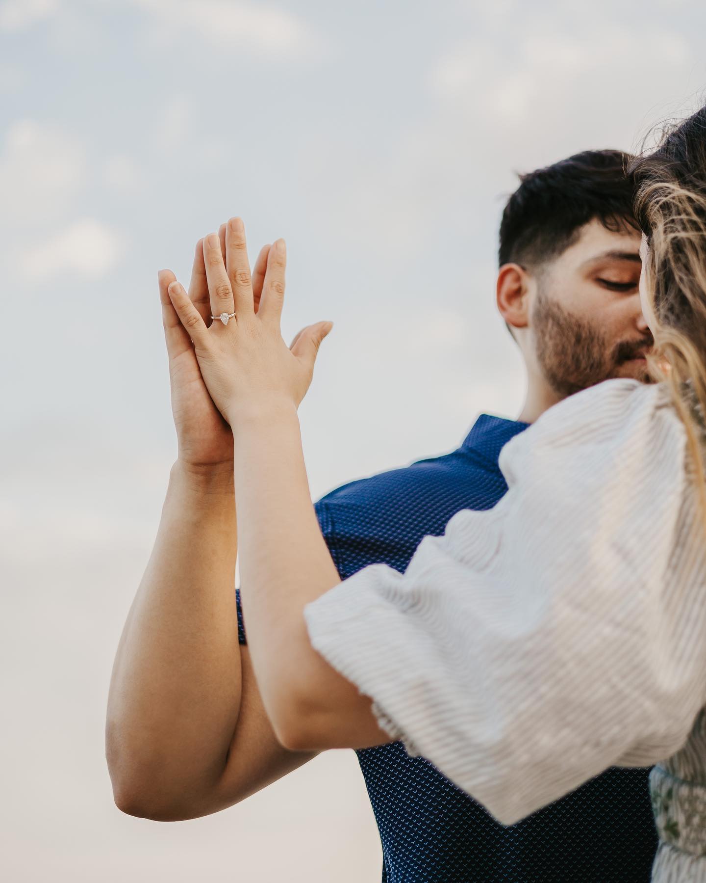 A man and woman hugging in a loving embrace during their engagement session.