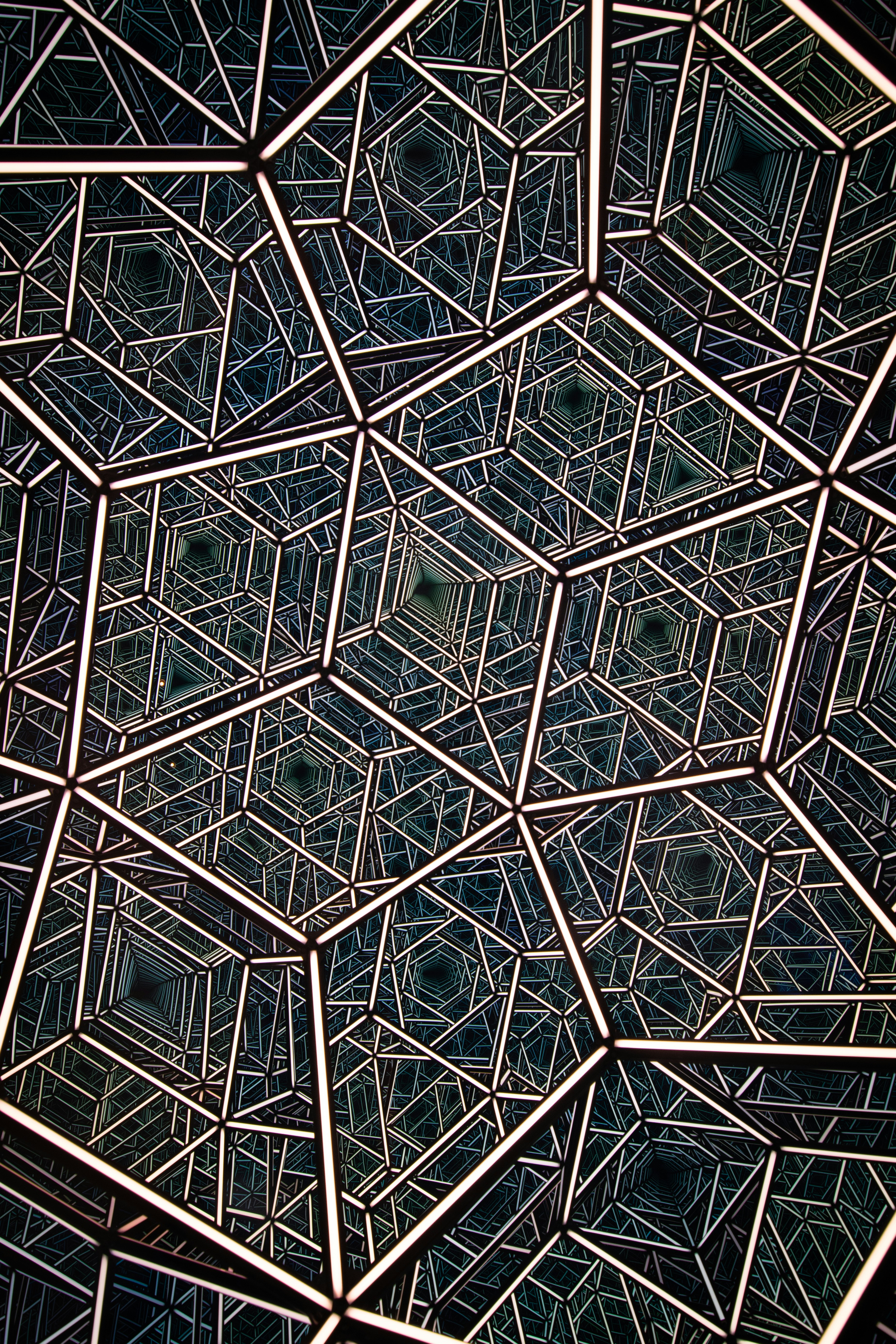 A smiling young man with crossed arms, wearing a plaid shirt and white t-shirt, poses against a dark background.