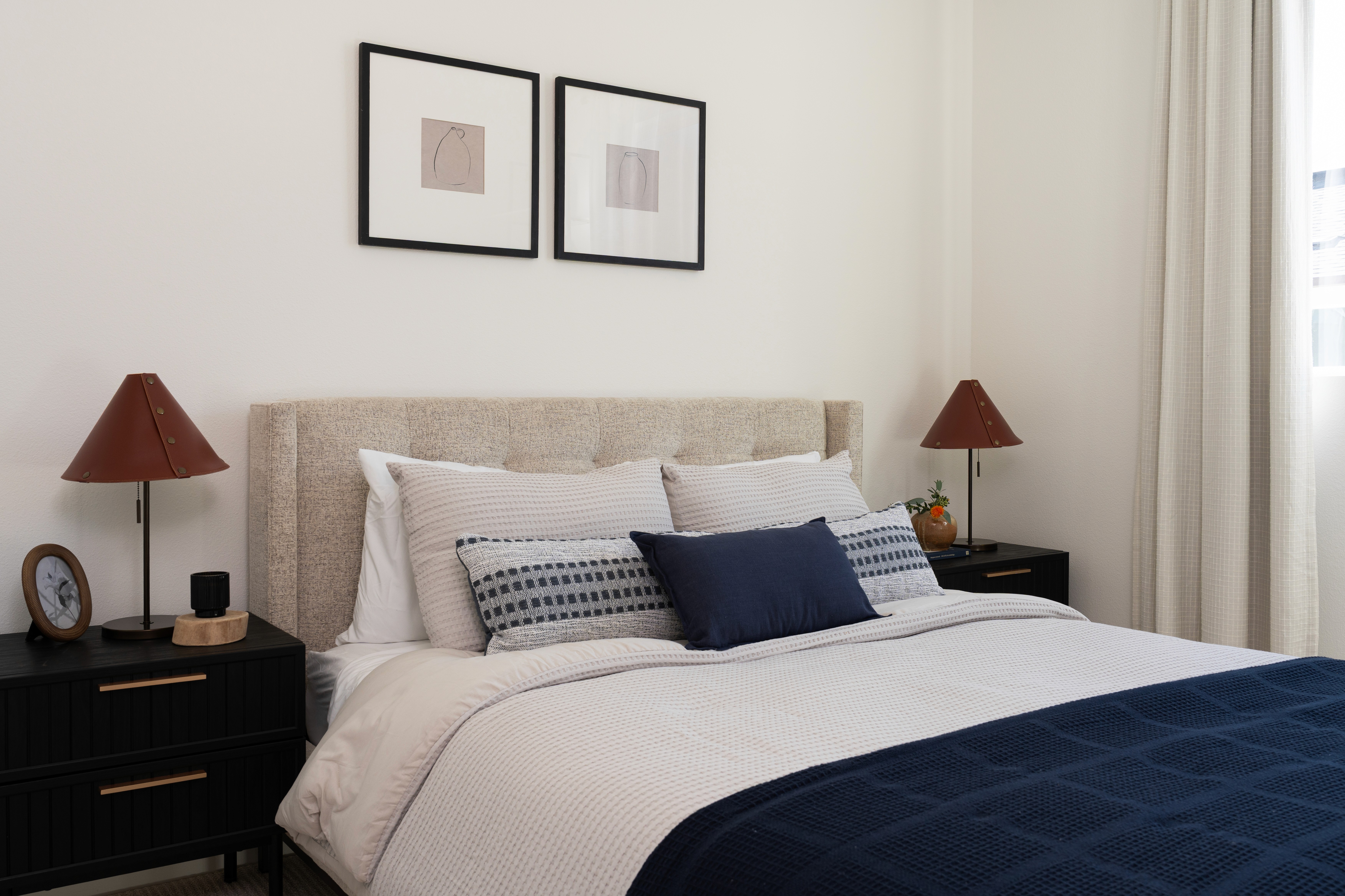 View of guest bed, side tables, and artwork