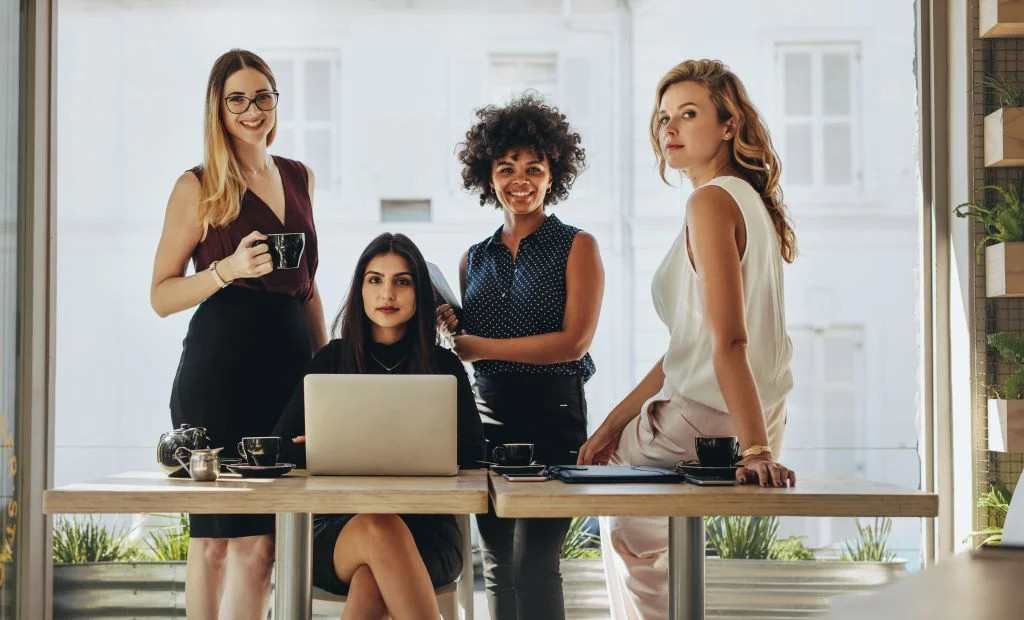 Women at desk posing for camera