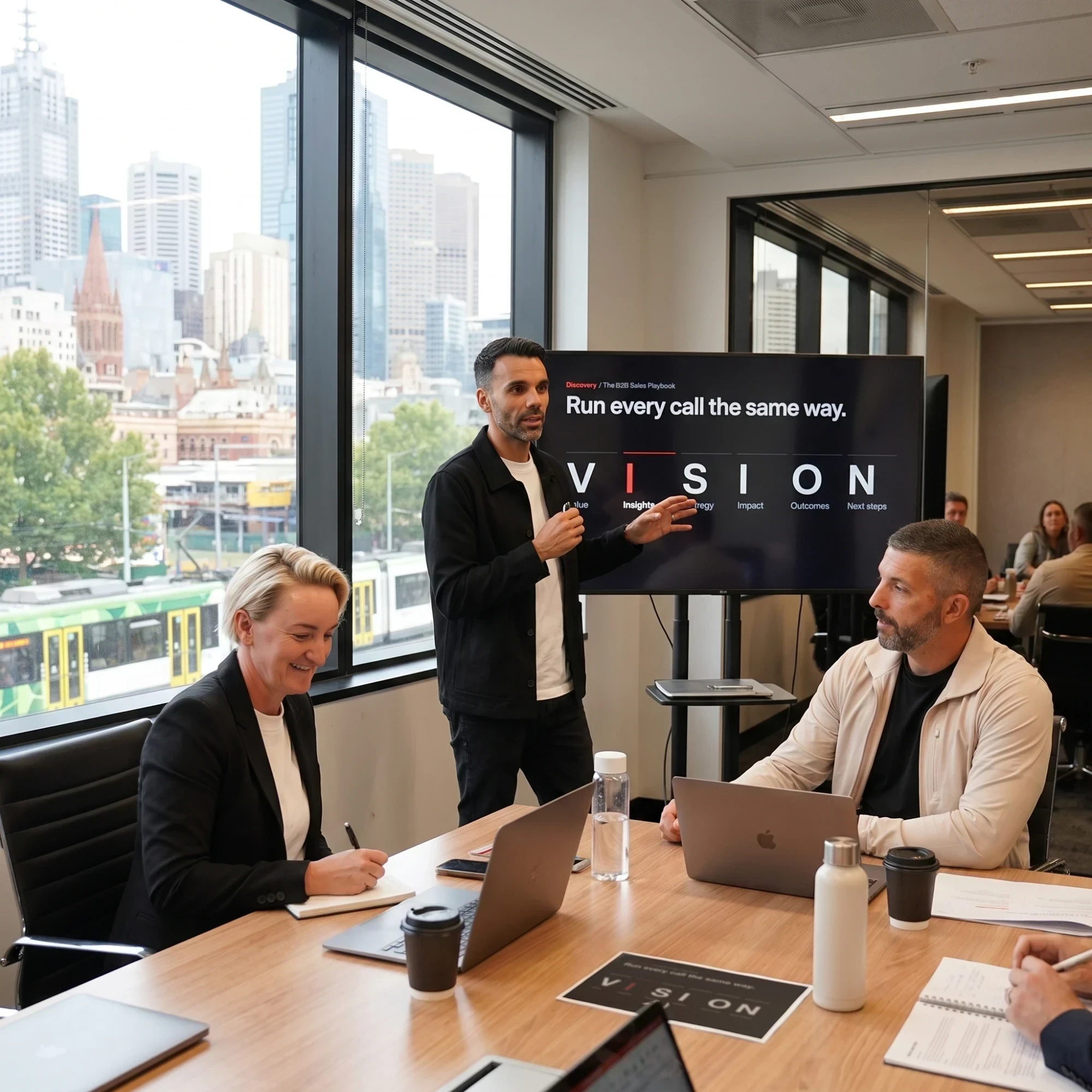 Luigi Prestinenzi presenting to a team around a meeting table, with a slide that reads Run every call the same way