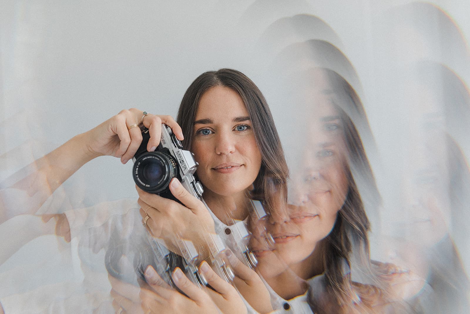 A photographer holding a camera, with a kaleidoscope effect capturing the creative spirit of Revelator Studio, a Shreveport natural light photography studio.