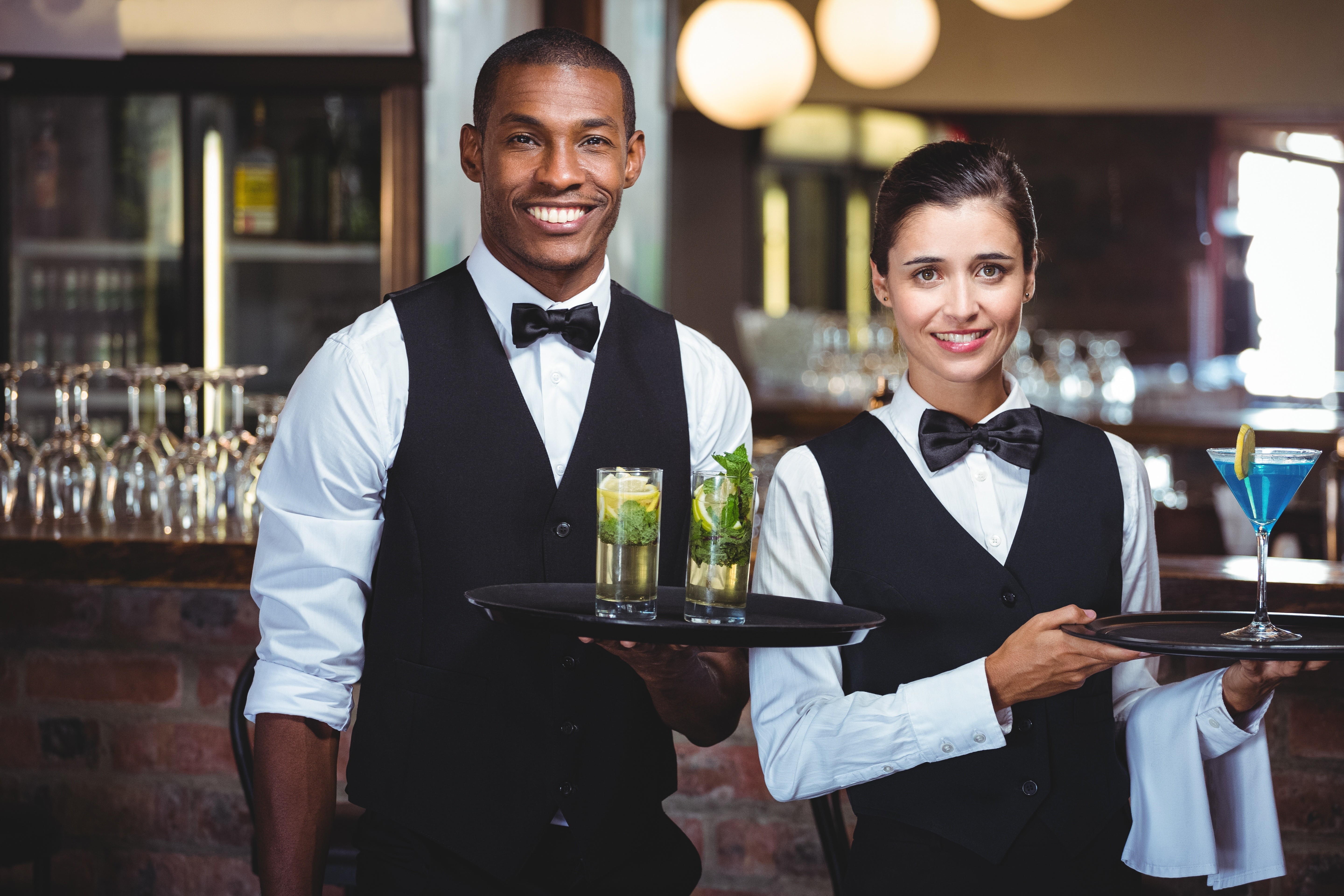 A waiter & waitress holding a tray.