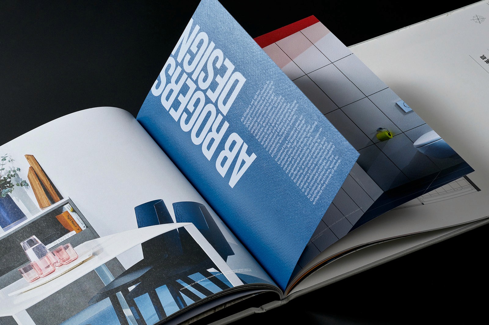 An open magazine resting on a dark surface, displaying various colorful pages and images.