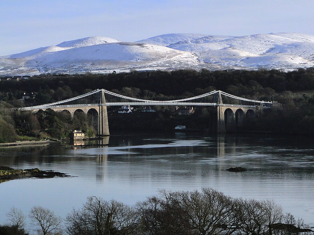 Menai Suspension Bridge with heavy goods vehicles in the background, highlighting the increased weight limit for logistics operations.