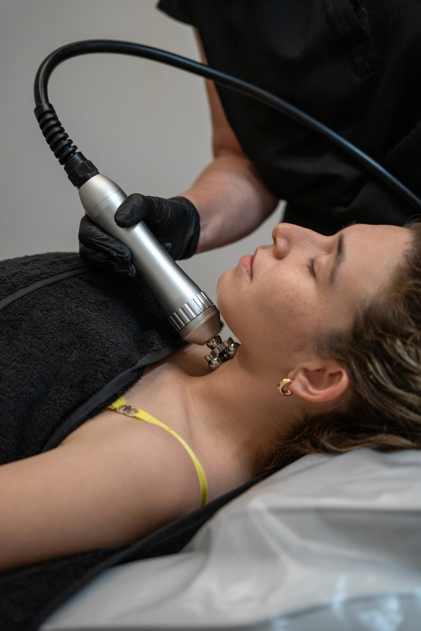 Facial massage device on woman's neck