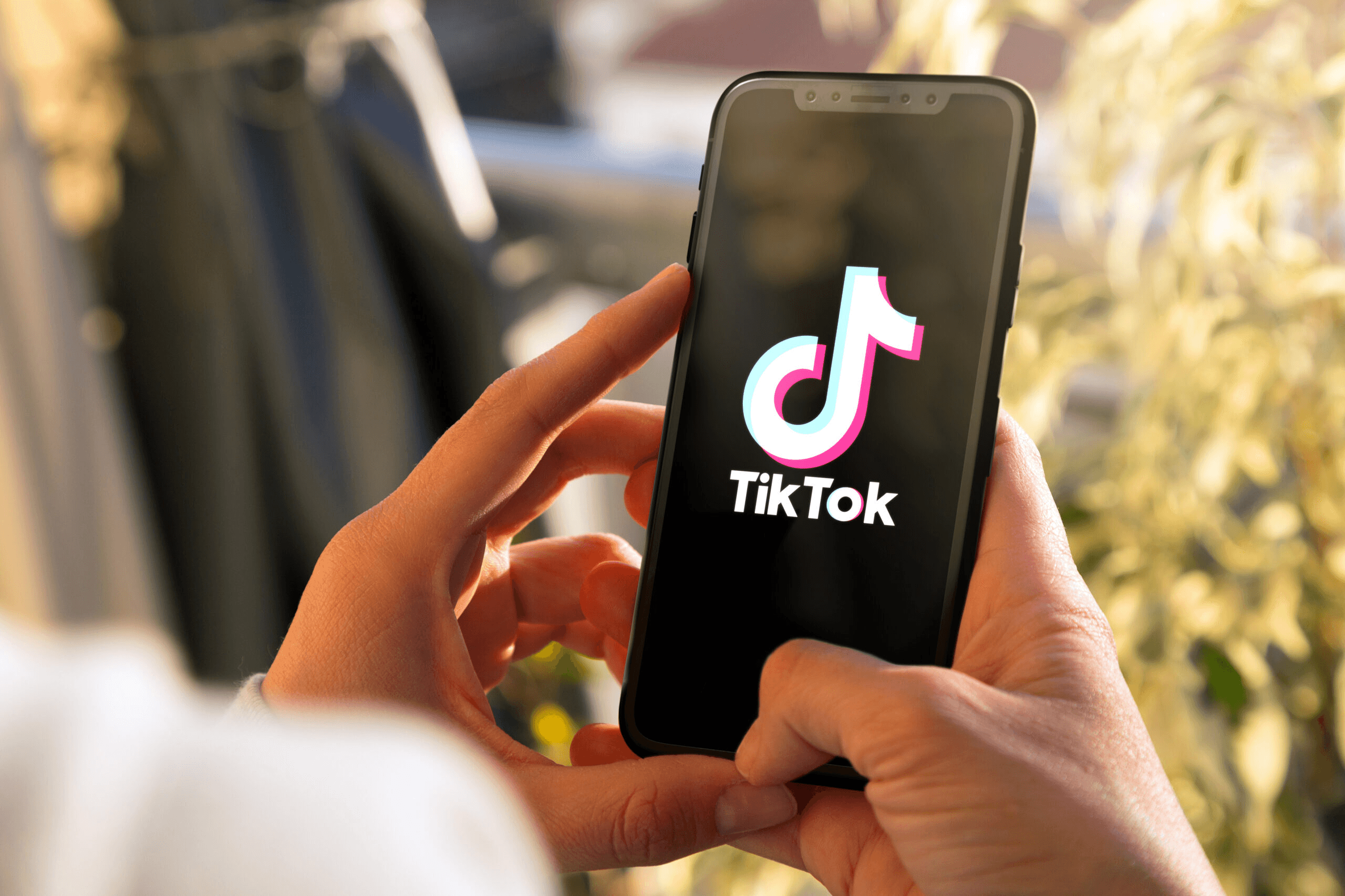 Hands holding smartphone displaying TikTok app - Tiktok Content Strategy