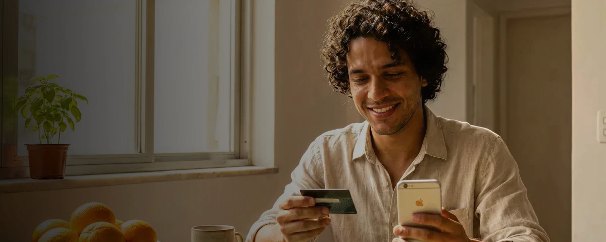 Homem com um celular e um cartão de crédito na mão