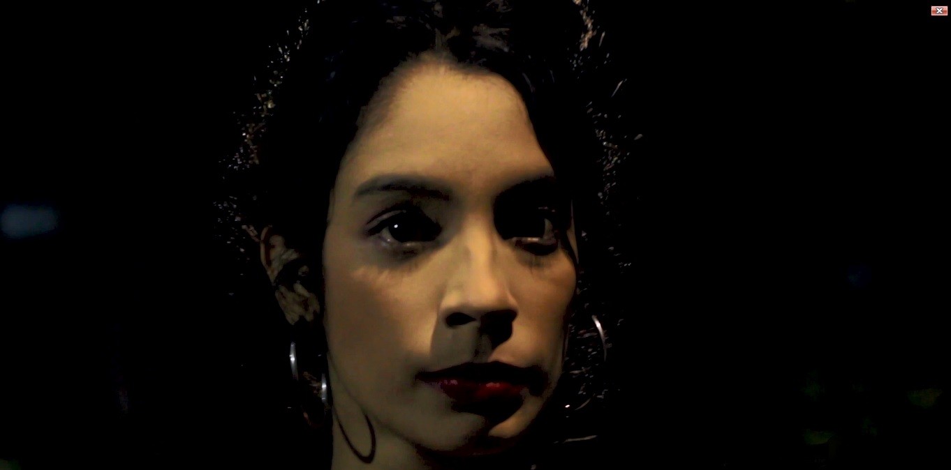 Woman in a light suit sitting thoughtfully against a terracotta wall