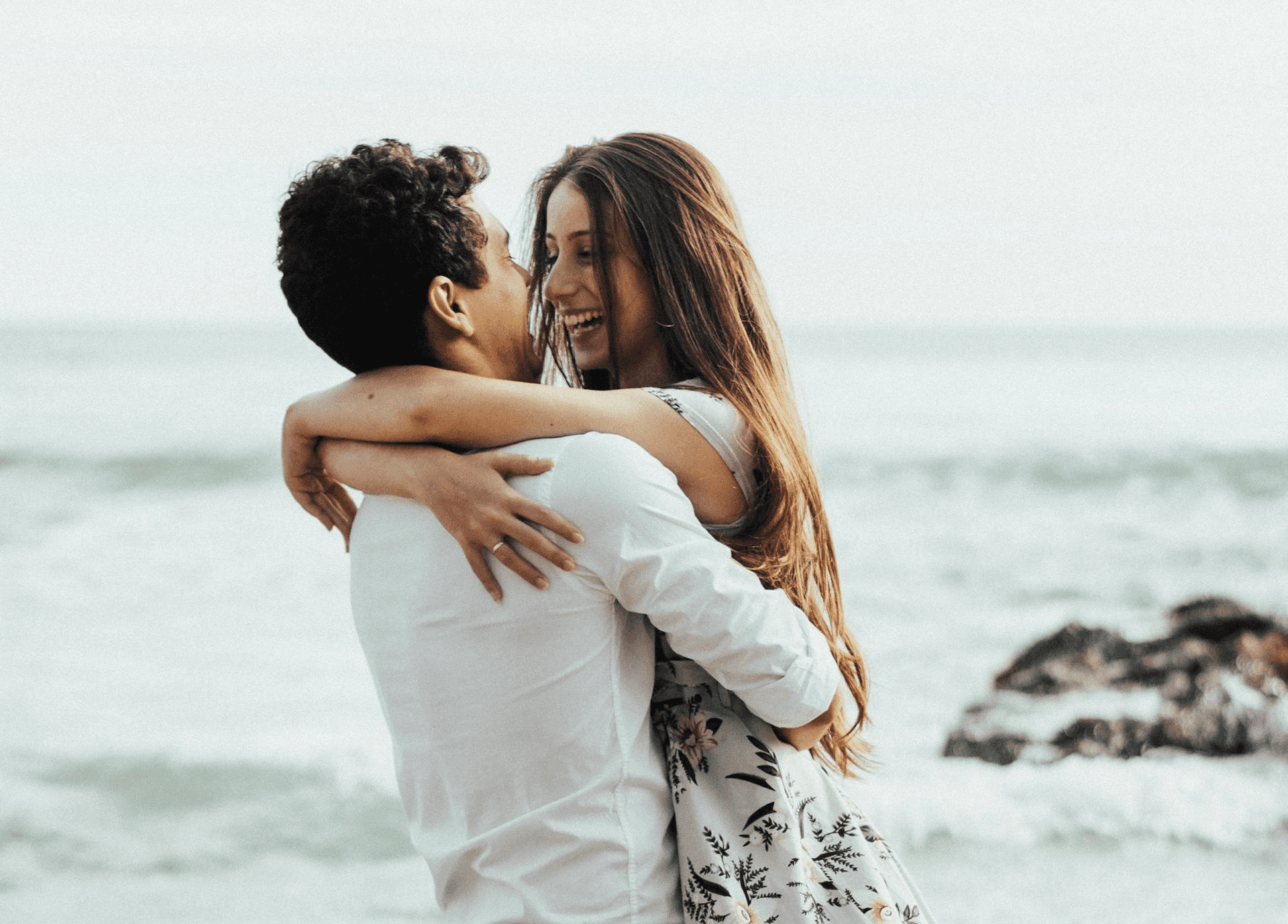 Happy couple hugging by the sea, symbolizing relationship harmony