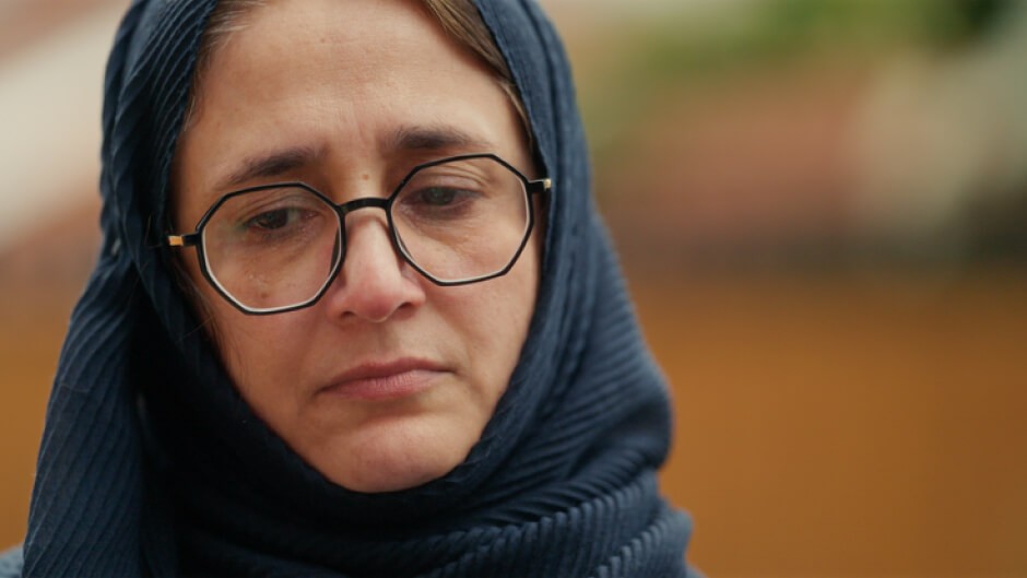 A sad looking SAIMA ANWAR wearing glasses and a blue head scarf