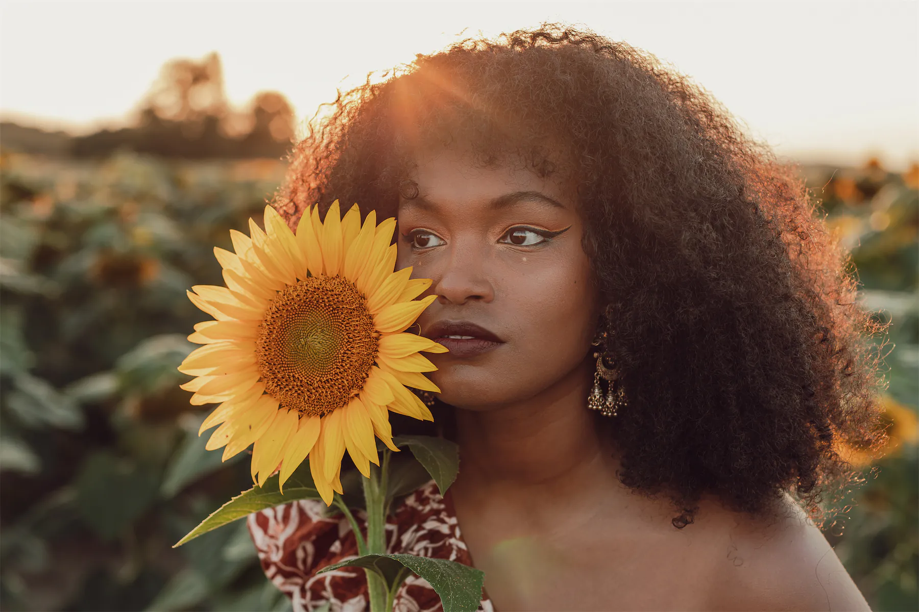 Femme au milleu d'un champs de tournesols