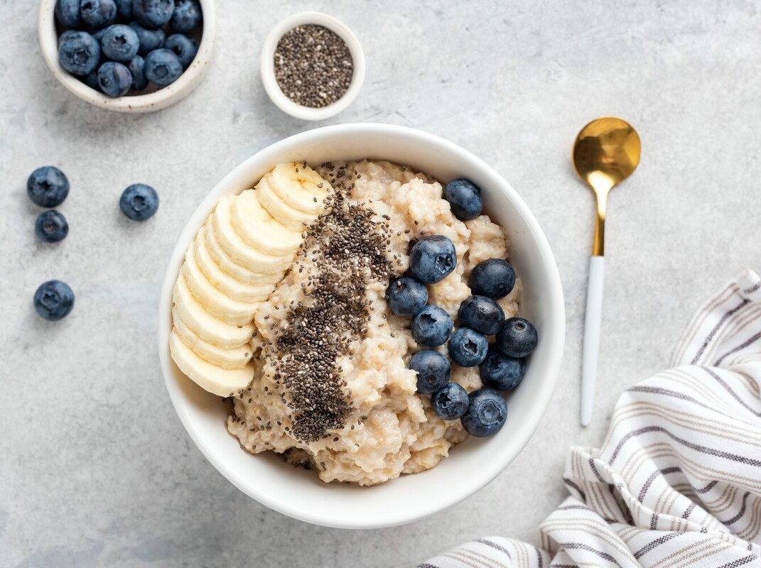 a healthy breakfast of oatmeal with banana and chia seeds and blueberries to improve Epsom salt soak weight loss results