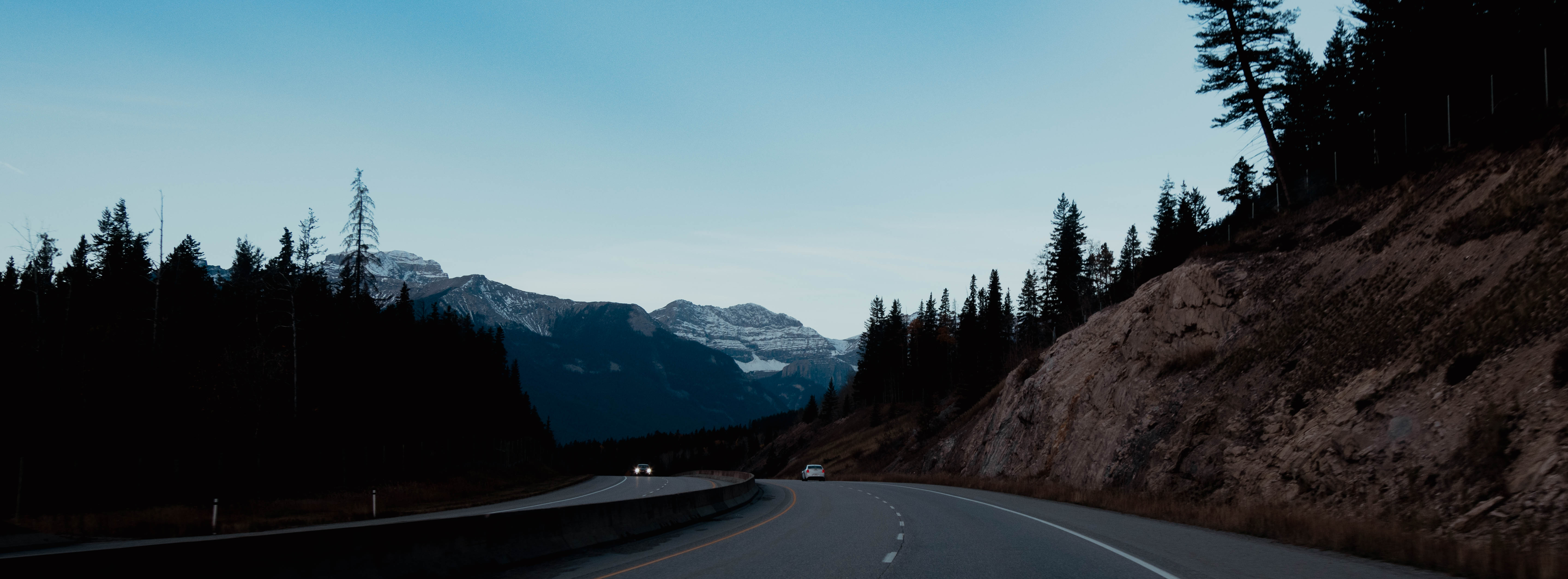 Two filmmakers operate a large camera in a dimly lit studio, wearing headphones and focused intently on the screen, conveying concentration.