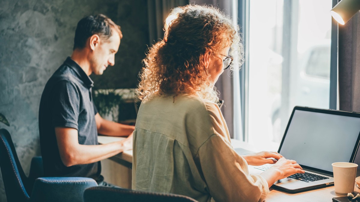 Two workshop facilitators sitting a front of their laptops during a remote, online workshop.