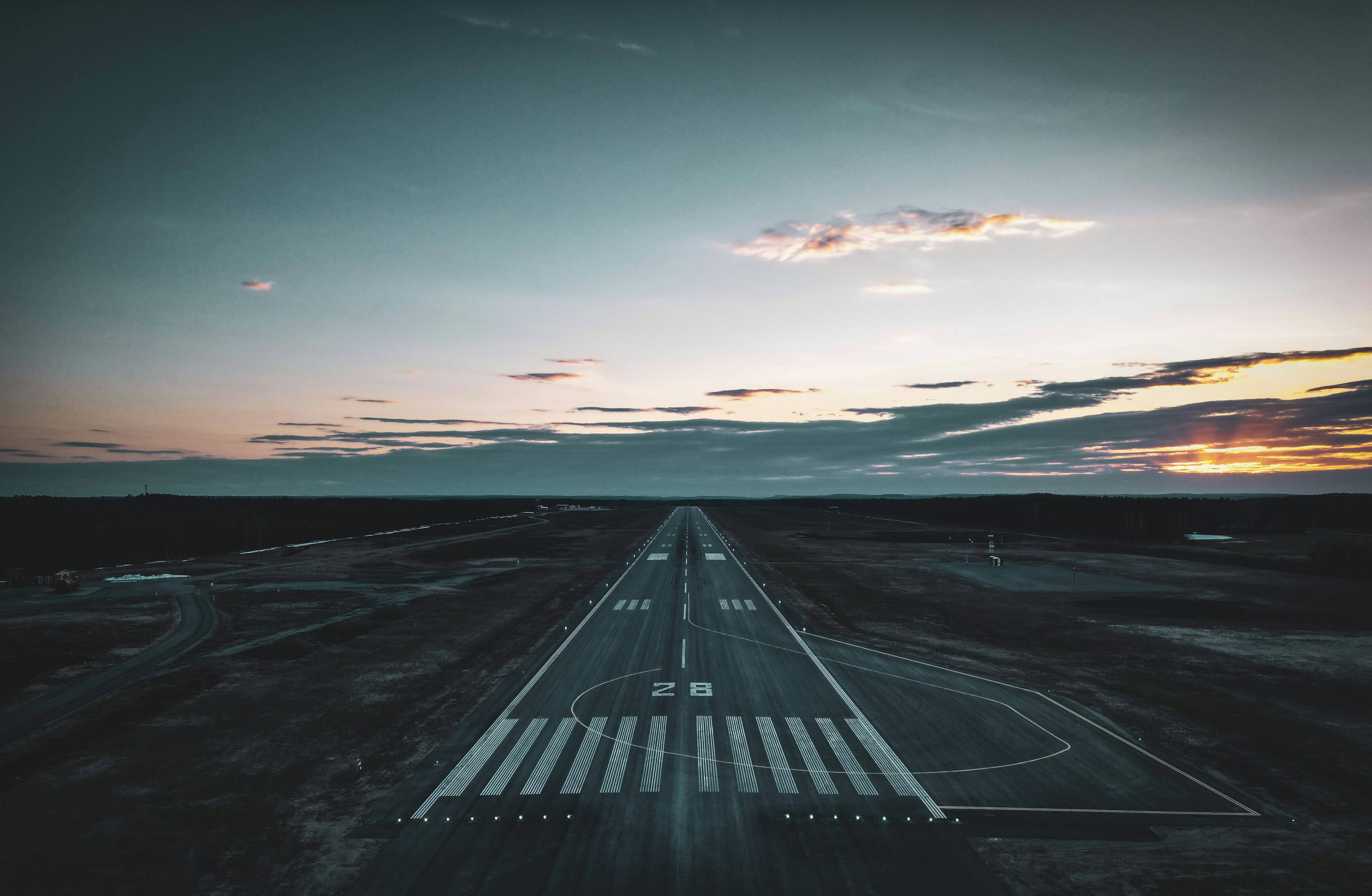 an aerial view of an airport runway at sunset