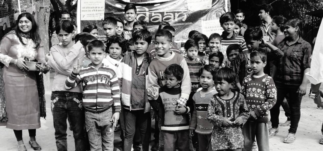 five children smiling while doing peace hand sign