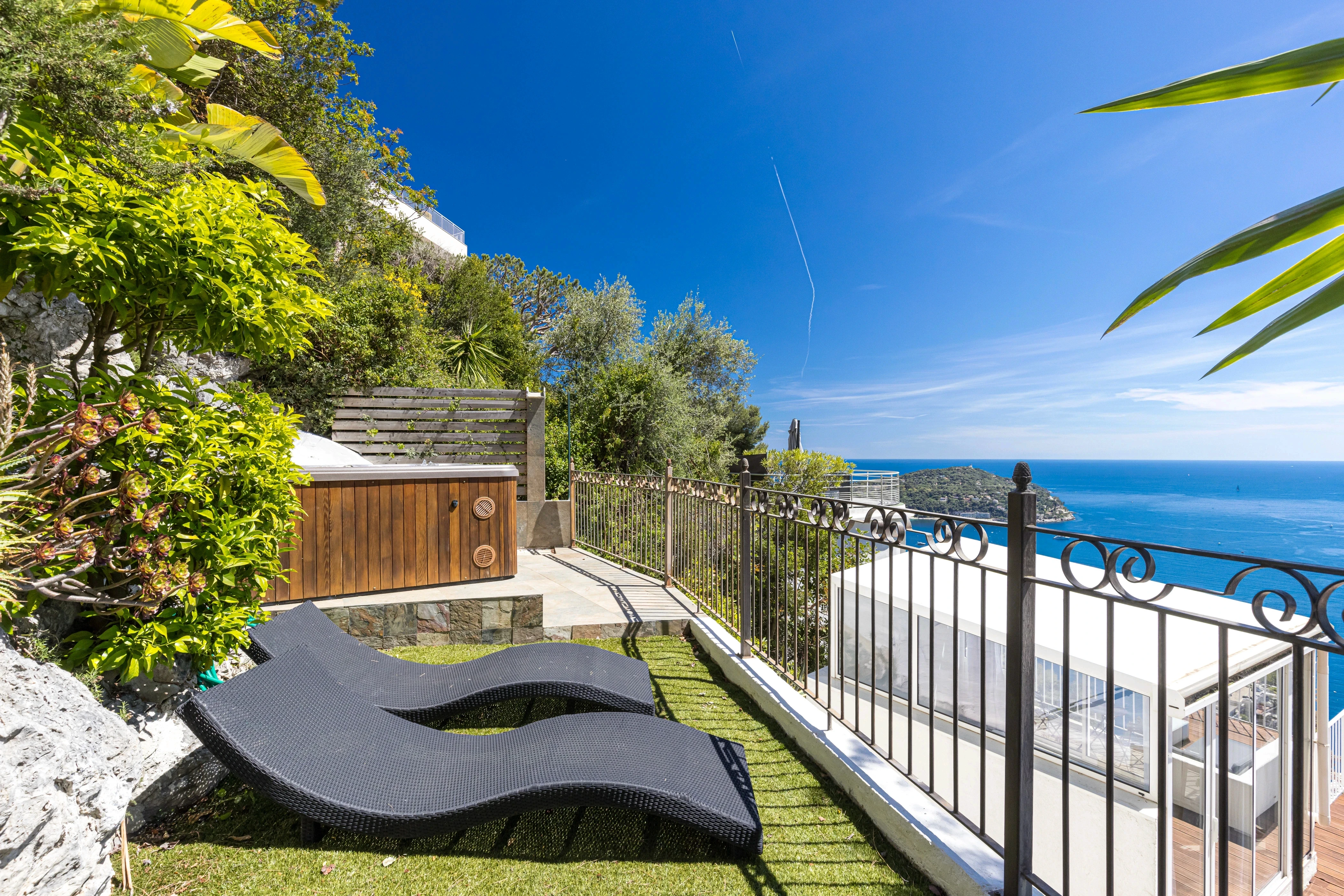 Photographie d'un balcon ensoleillé avec vue sur la Côte d'Azur