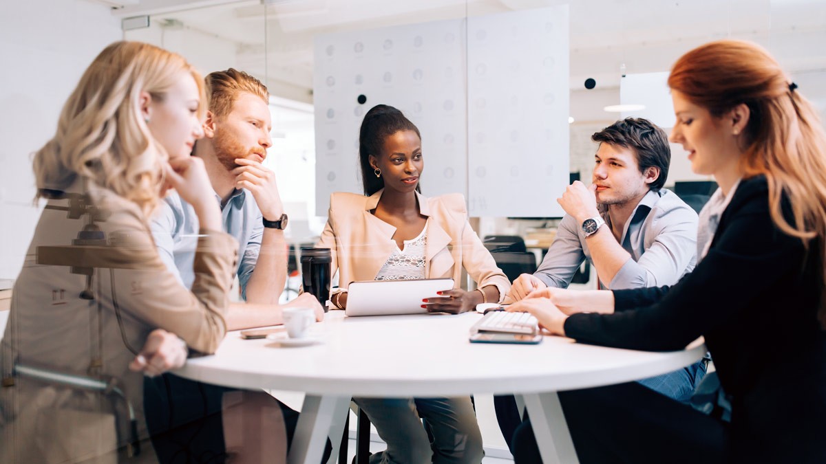 A group of coworkers sitting around a round table during a meeting