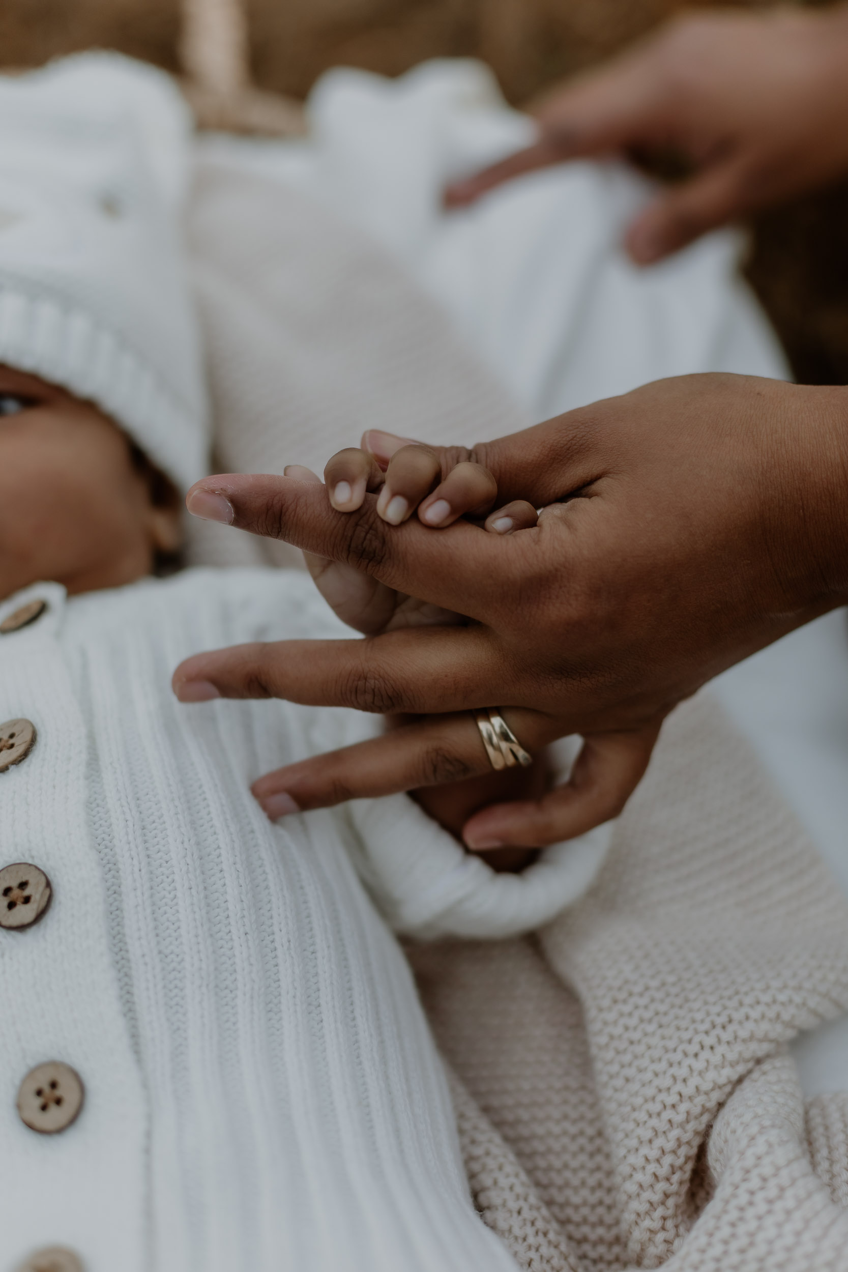 Close up of parent holding newborn baby's hand