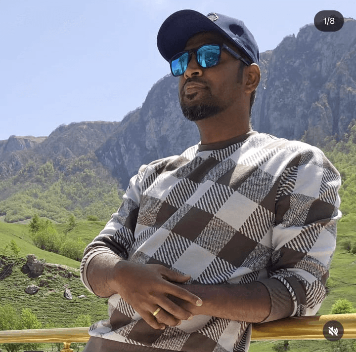 Portrait of a young man with curly hair wearing a yellow hoodie and backpack