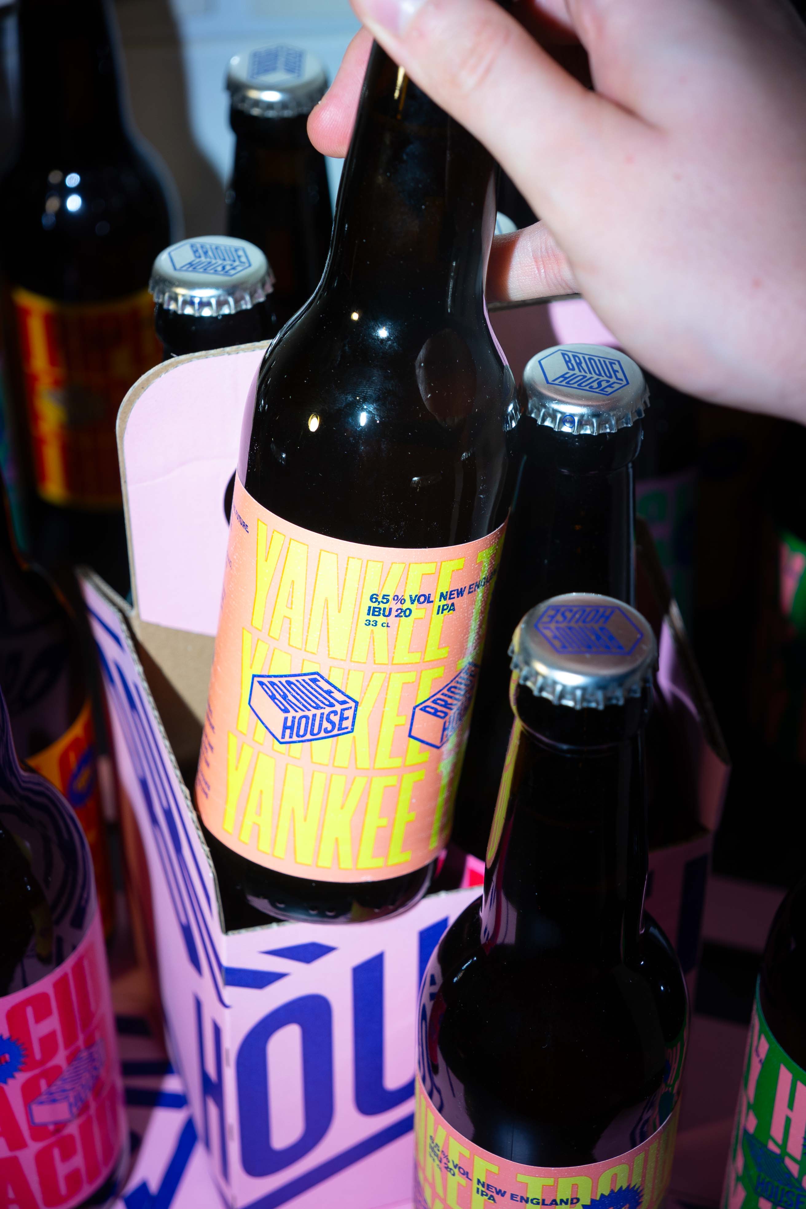 Photo d'une main prenant une bière dans un pack