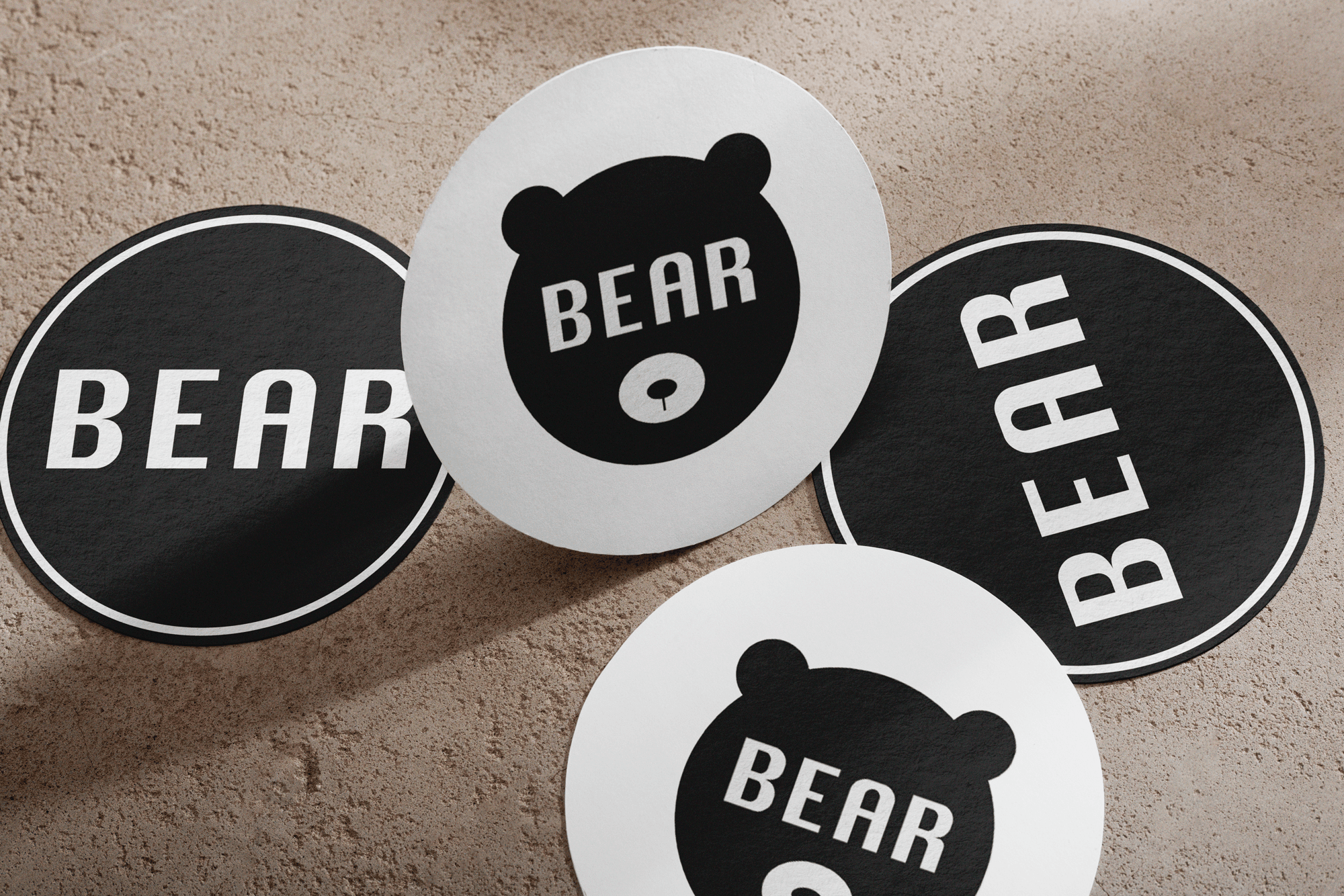 Four minimalistic, black and white coasters with 'BEAR' logo in the center. 