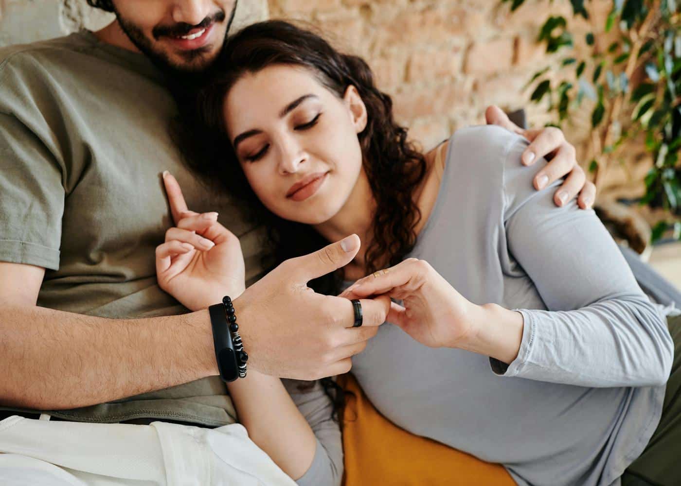 Man and woman holding hands while the man is wearing a black Oura ring